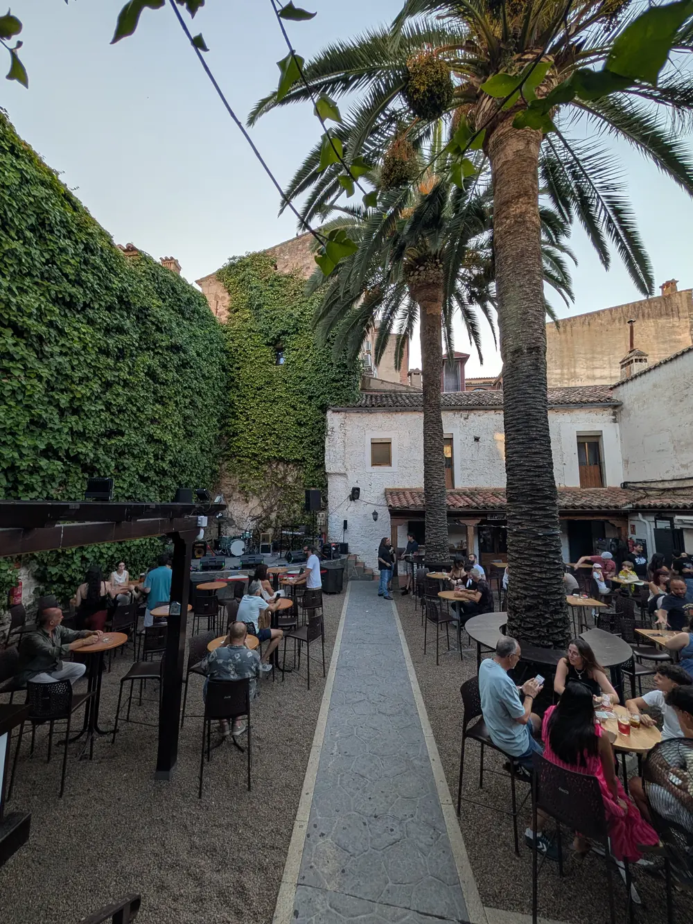 El mismo rincón del patio al caer la tarde, con las primeras mesas ocupadas