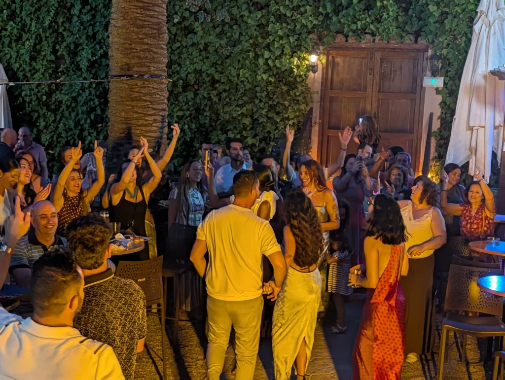 Gente bailando de noche junto al portón de madera