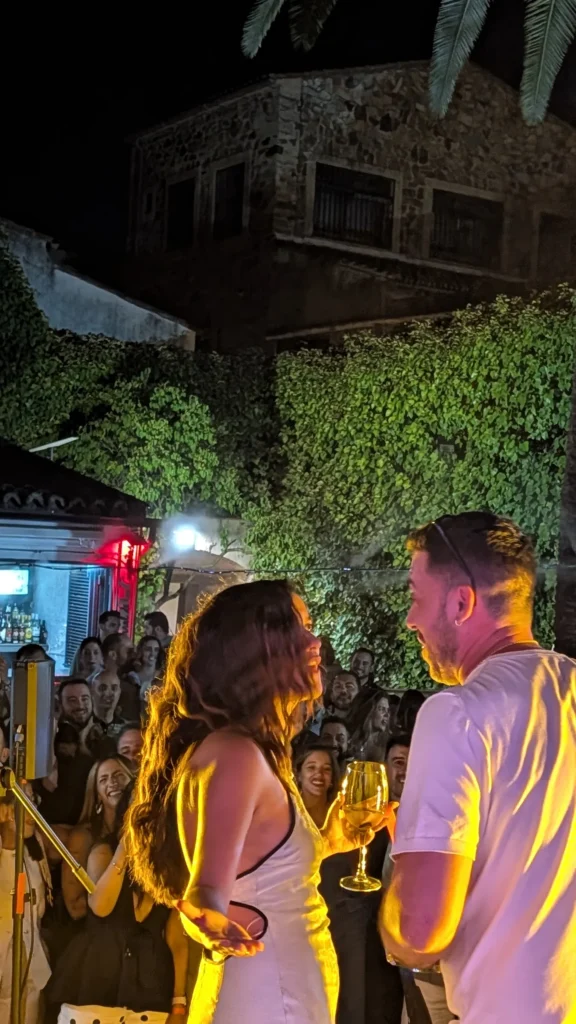 Una pareja charla con su copa bajo la luz cálida de la noche