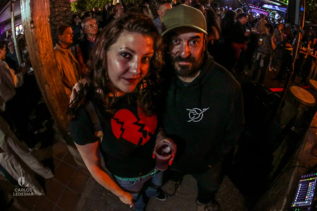 Una pareja mira a cámara en mitad de un concierto de noche