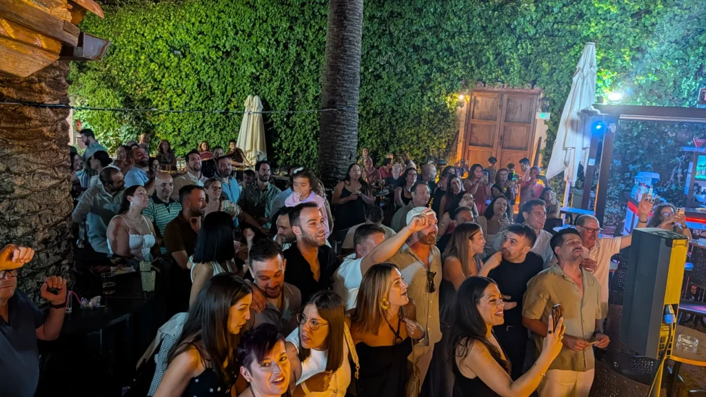 Gente bailando y cantando en medio del patio