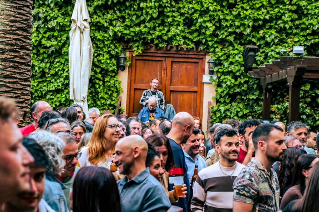Público escuchando un concierto de día, de pie en el patio
